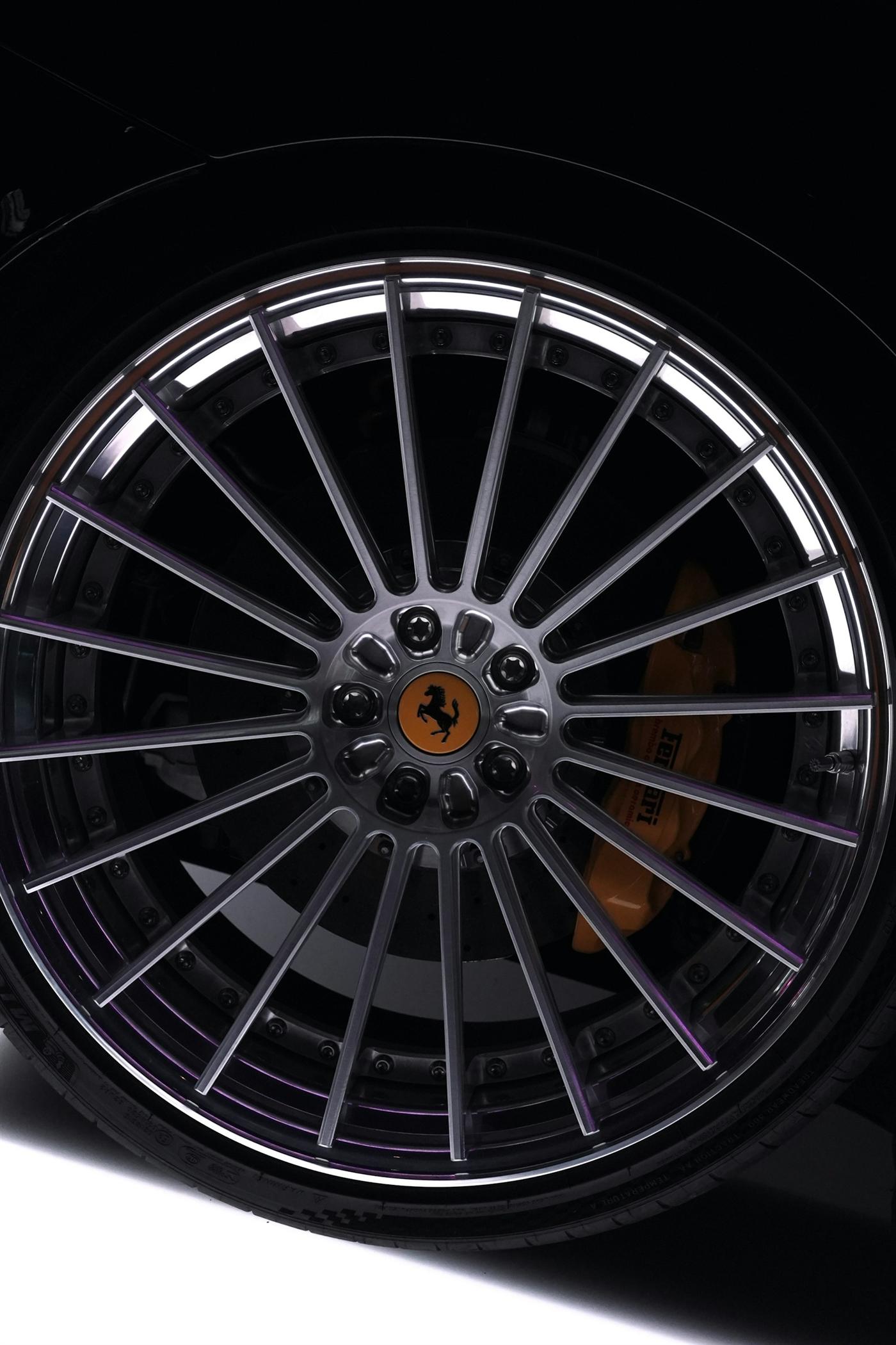 Multi-spoke alloy wheel with a prancing horse centre cap against a black arch