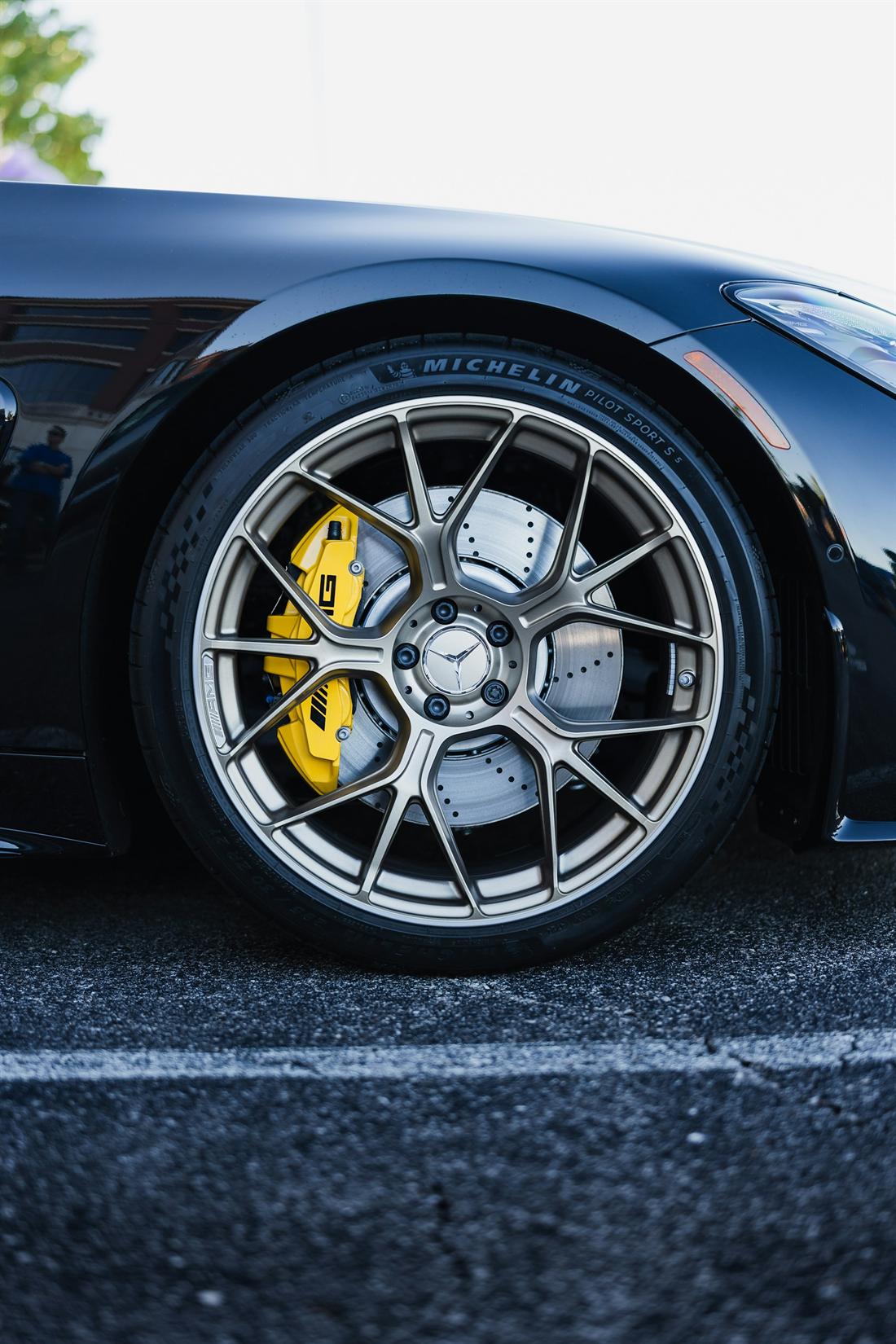 Forged alloy wheel with yellow brake caliper on a dark sports car