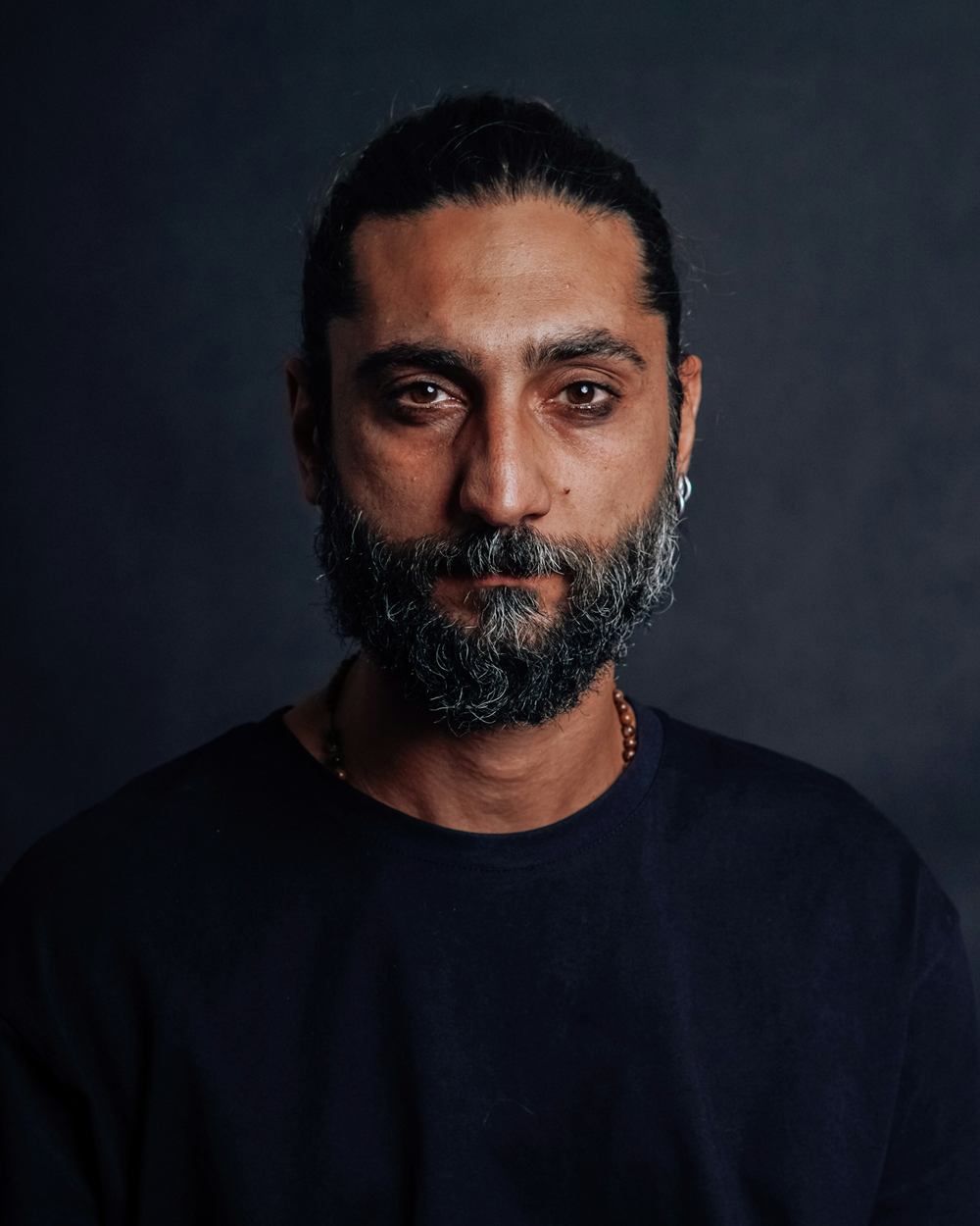 Portrait of Marcus Black, founder and master barber, against a dark backdrop