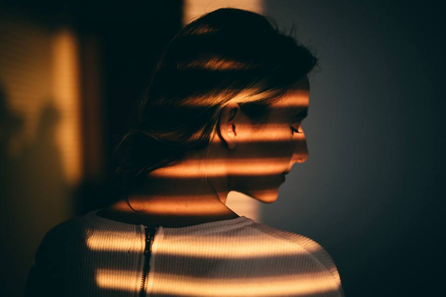 Window-blind light across a face